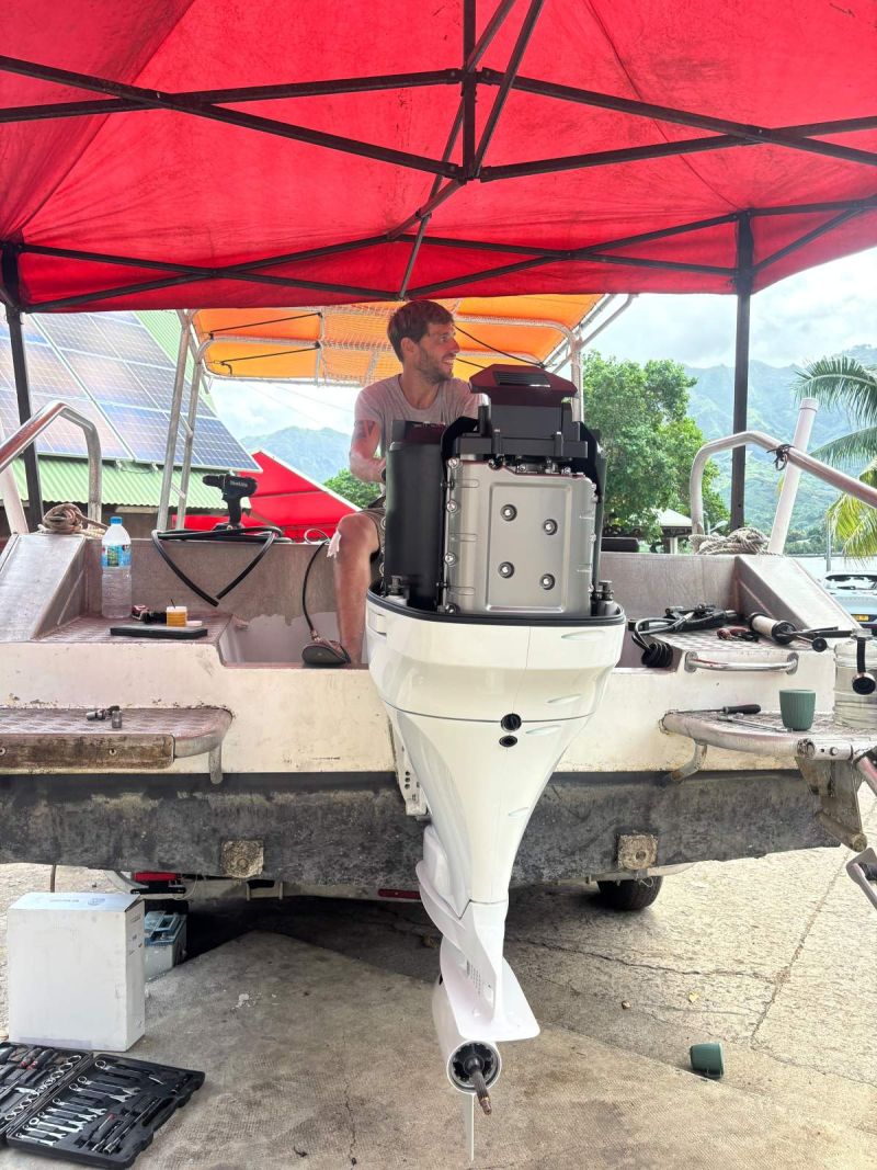 Moteur hors-bord Suzuki en cours de montage sur le tableau arrière d'un bateau, sous abri