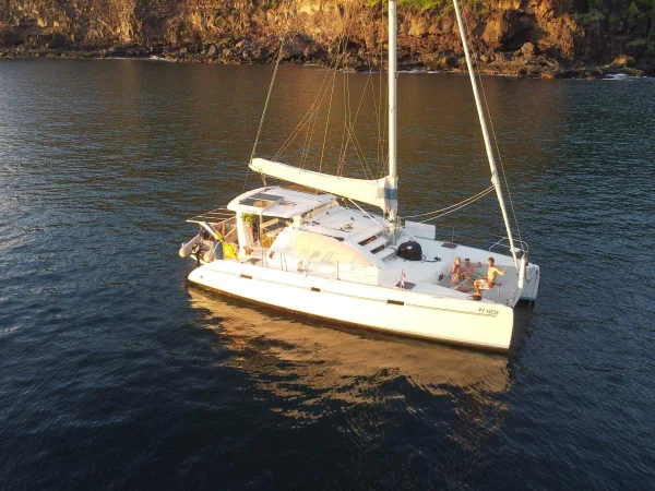 Le catamaran Toake Ona au mouillage au pied des falaises de Nuku Hiva