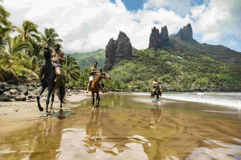 Promenade à cheval sur une plage des Marquises, pitons rocheux en arrière-plan