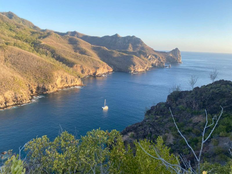 Voilier au mouillage dans une baie sauvage de Eiao, vue depuis la falaise