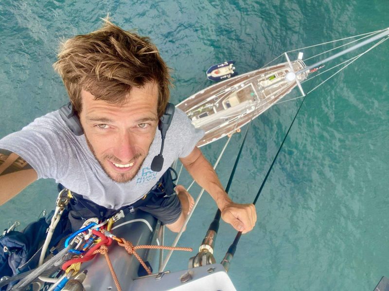 Gaël Minet en tête de mât, le voilier en contrebas