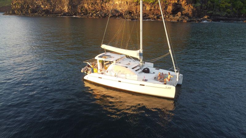 Le catamaran Toake Ona au mouillage au pied des falaises de Nuku Hiva